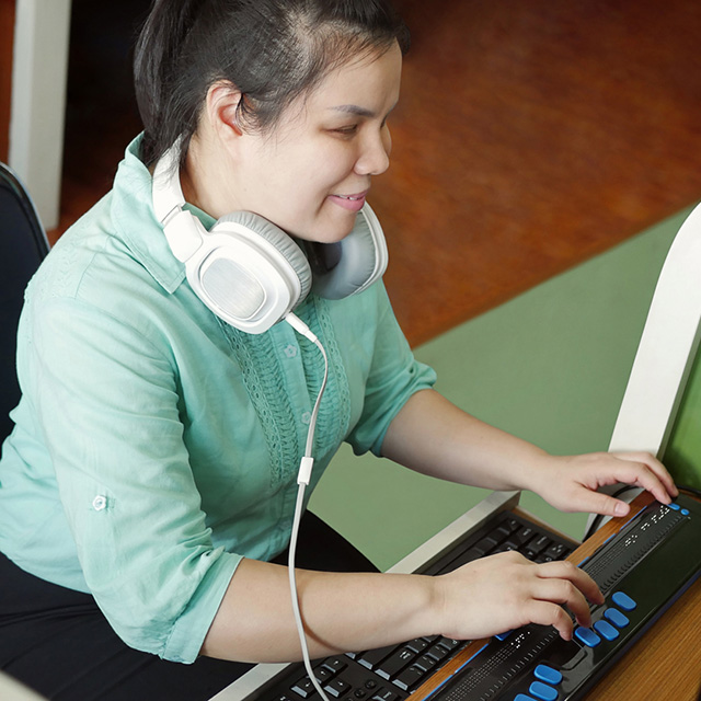 woman at a computer with headphones