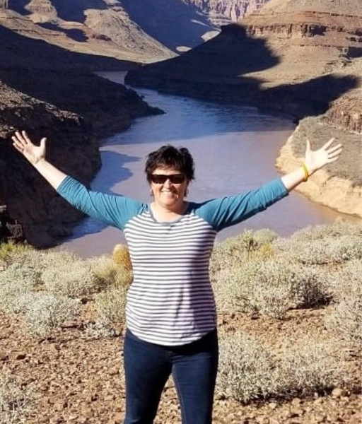Photo of Mary Brougher with a spectacular view of the Grand Canyon behind her